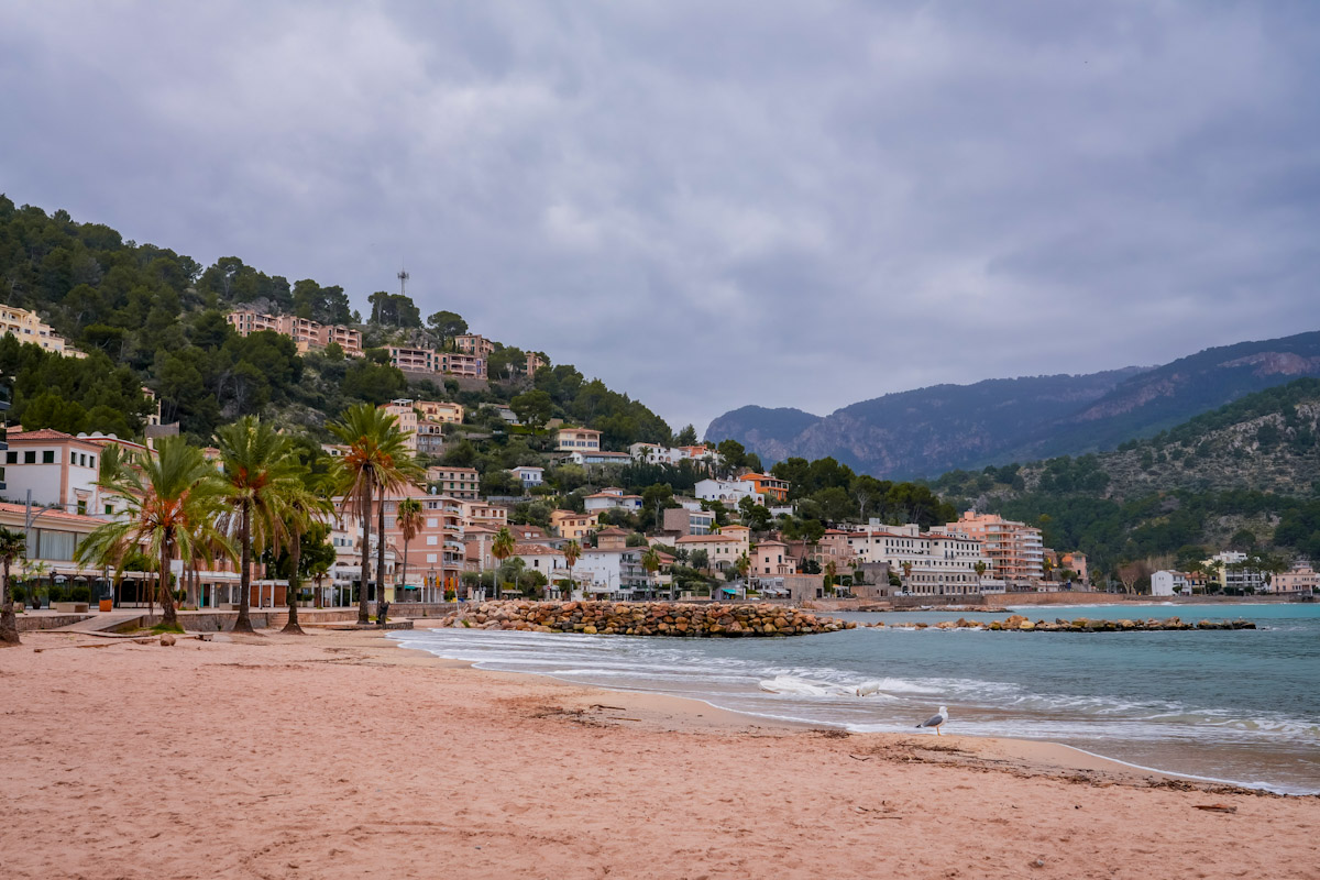 Port de Soller beach in Mallorca in winter with calm sea and coastal town under soft winter light