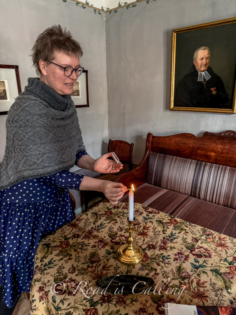 guide lighting a candle inside the 19th-century Tartu Citizen's Home Museum