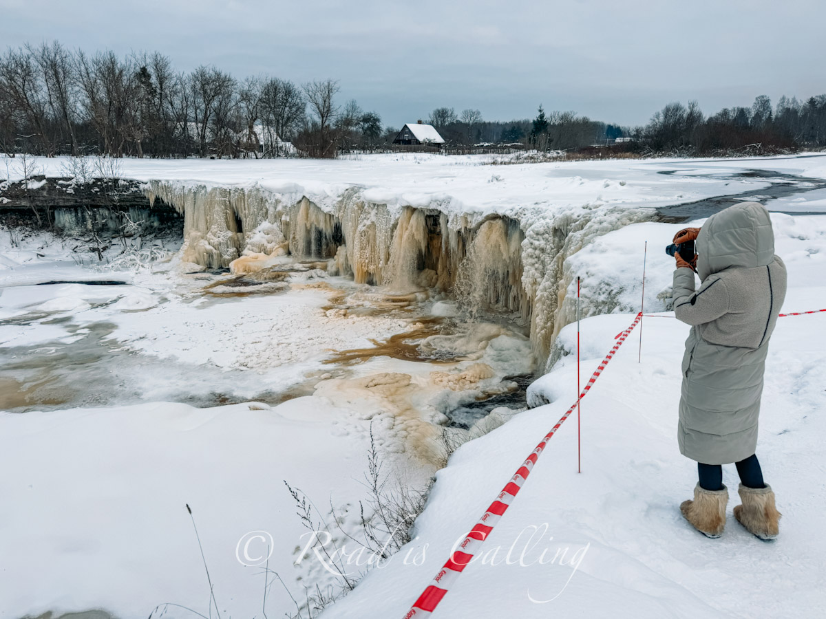 me taking photos of Jagala waterfall from a snowy cliff in winter