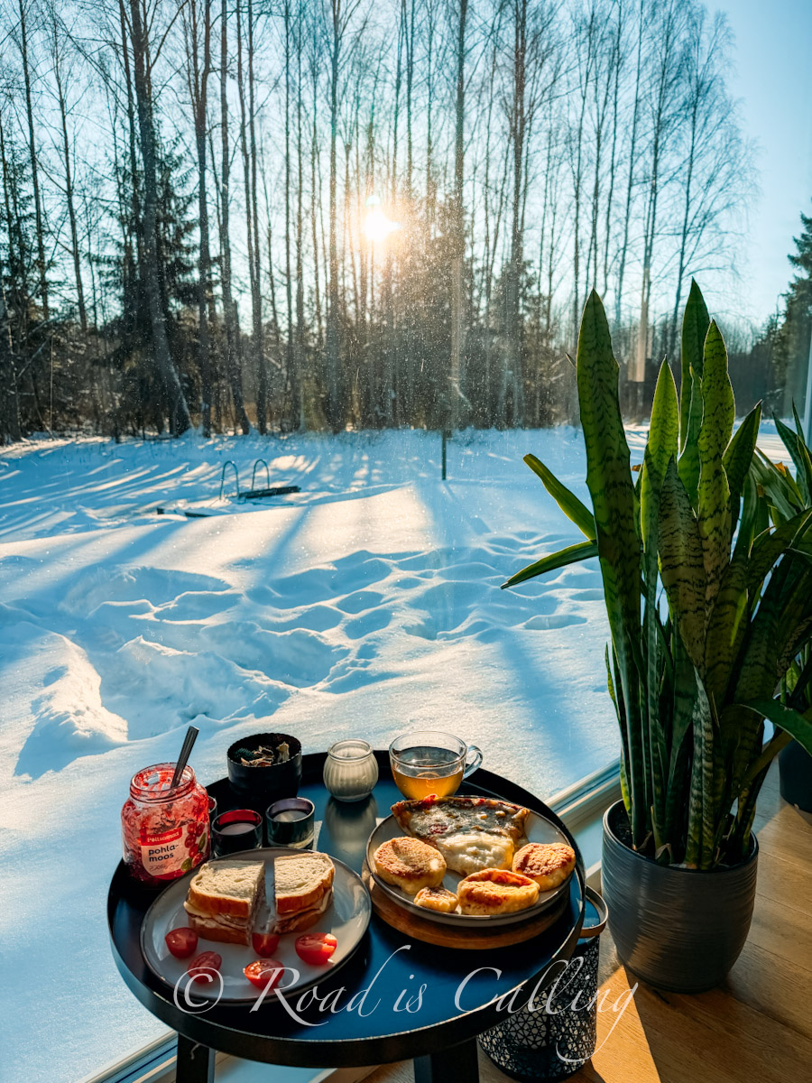 brunch by a window overlooking snowy forest in Lahemaa National Park
