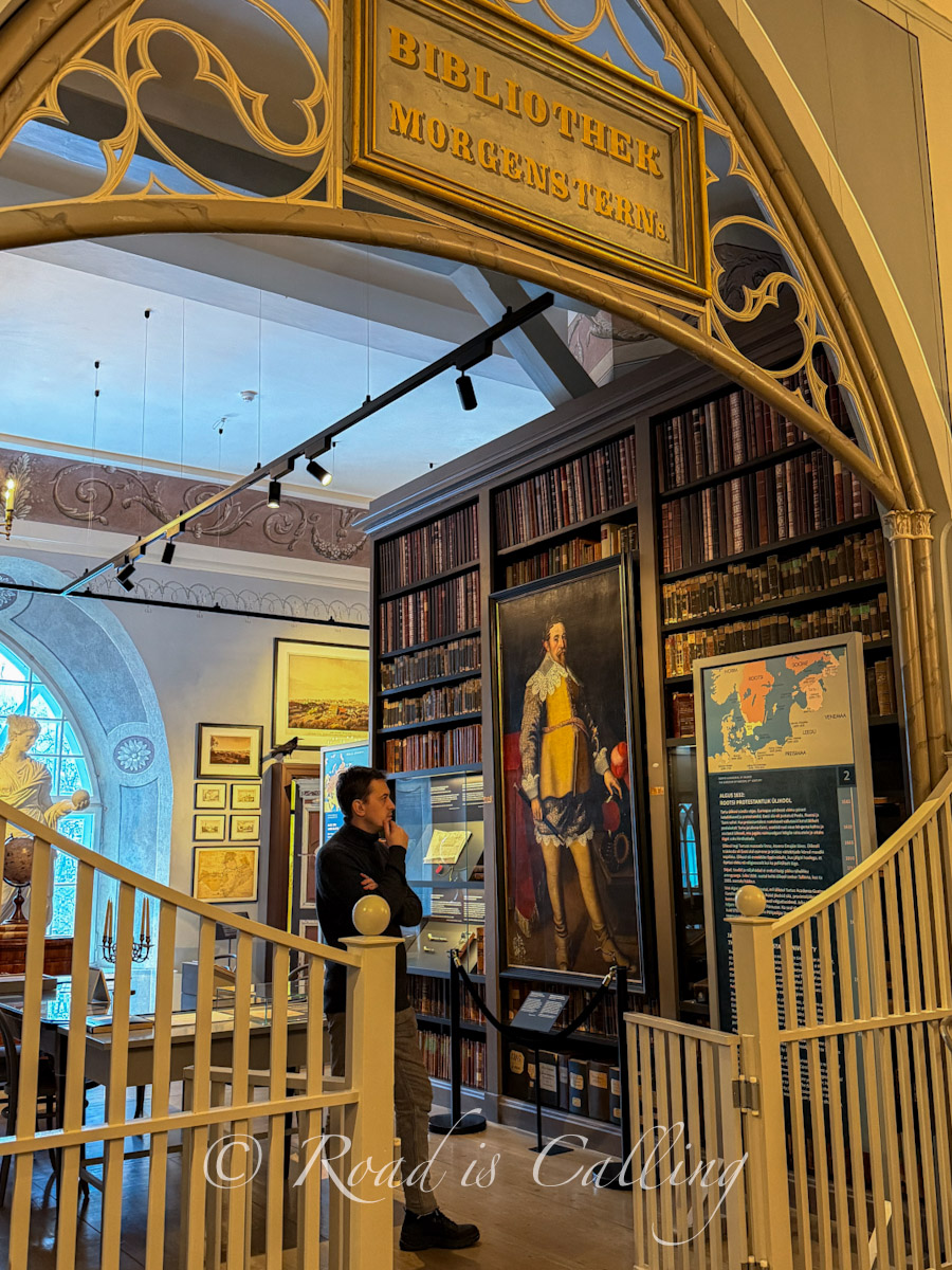 interior of University of Tartu Museum library room with historic books and portrait