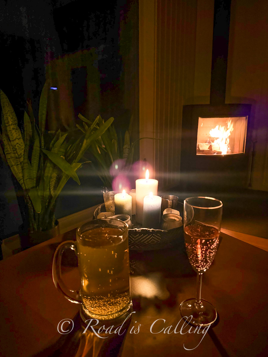 candles and drinks on a table by a fireplace in a cozy cabin in Lahemaa National Park