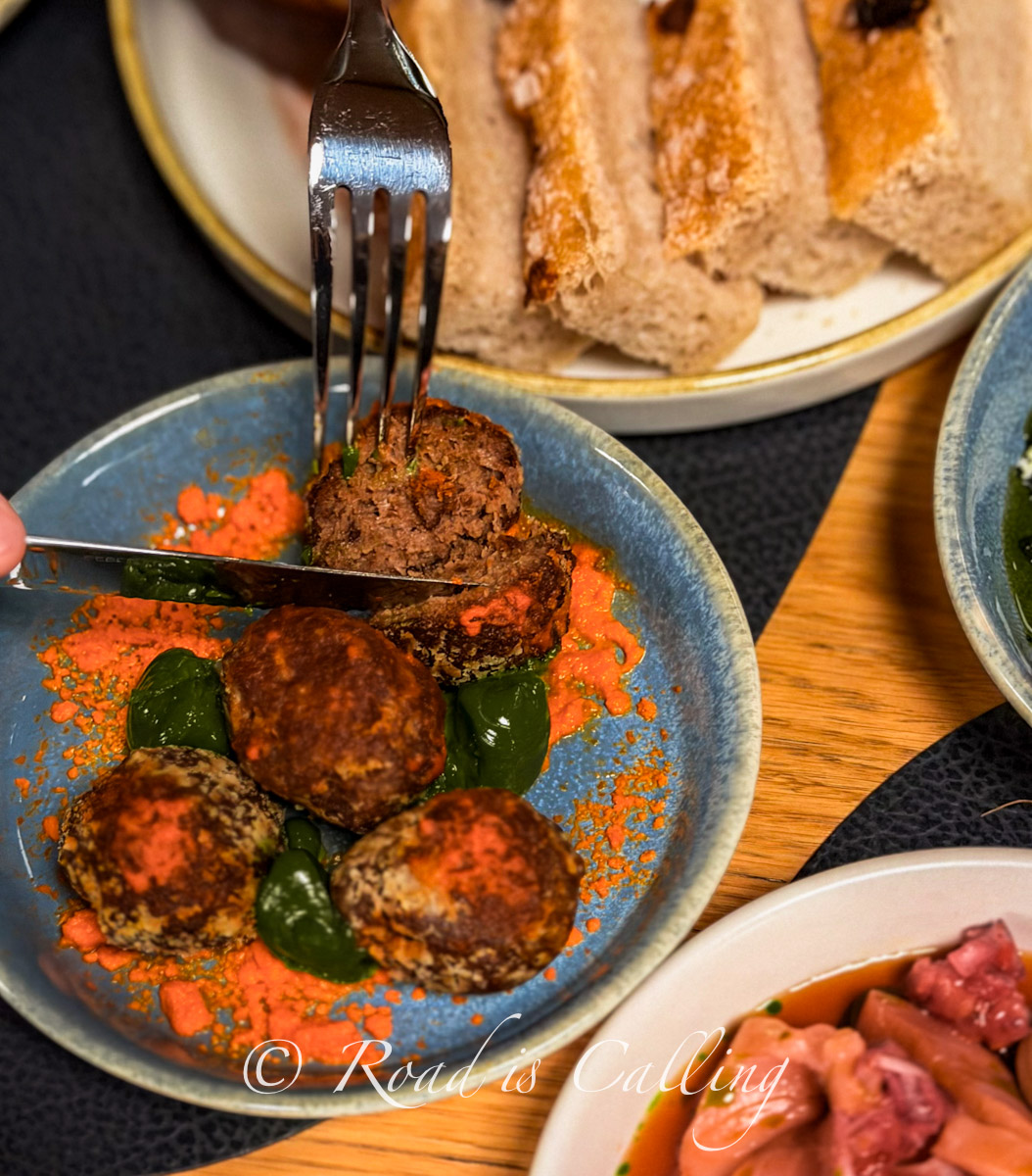close-up of a dish at Ugandi Resto with meat balls served in a bowl and secret sauce