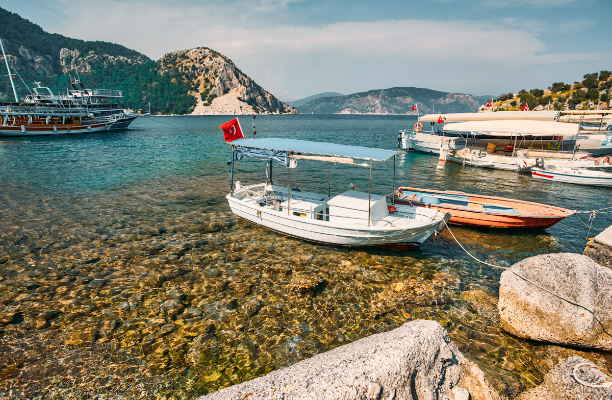 Traditional boat in crystal clear water near hidden coves around Marmaris and Turkish Riviera
