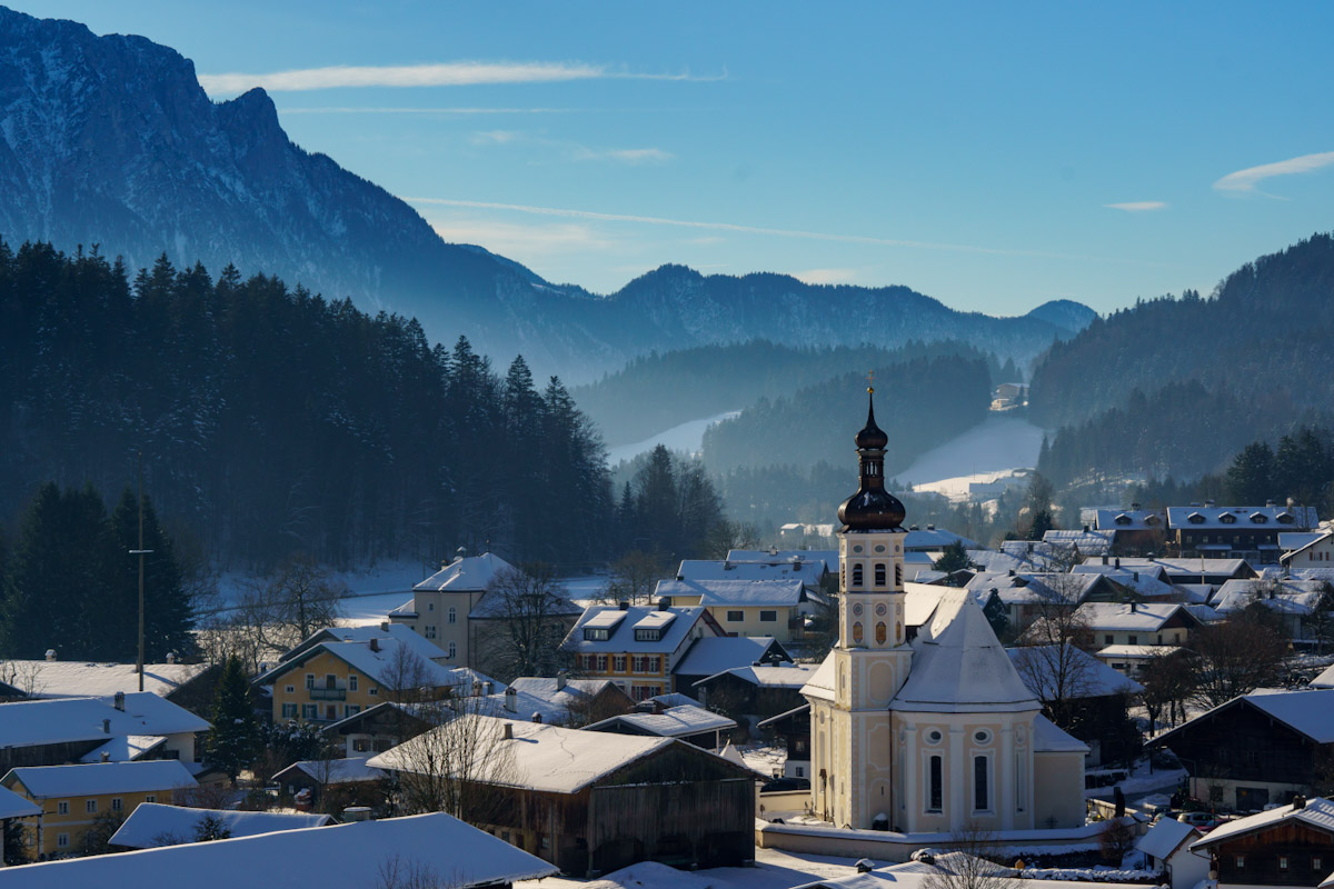 winter sunrise over Sachrang village with mountain peaks in the background