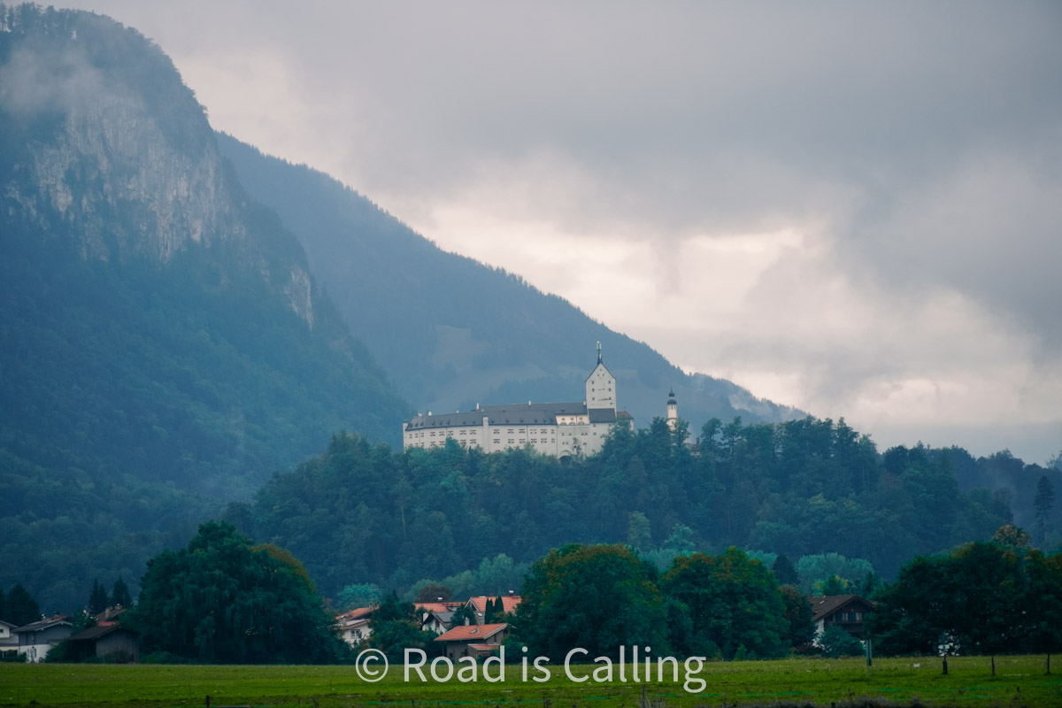 View of a hiltop castle and alpine mountains in a hidden Bavarian village