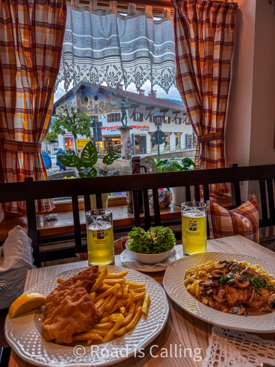 traditional Bavarian meal in a village restaurant with alpine views through the window