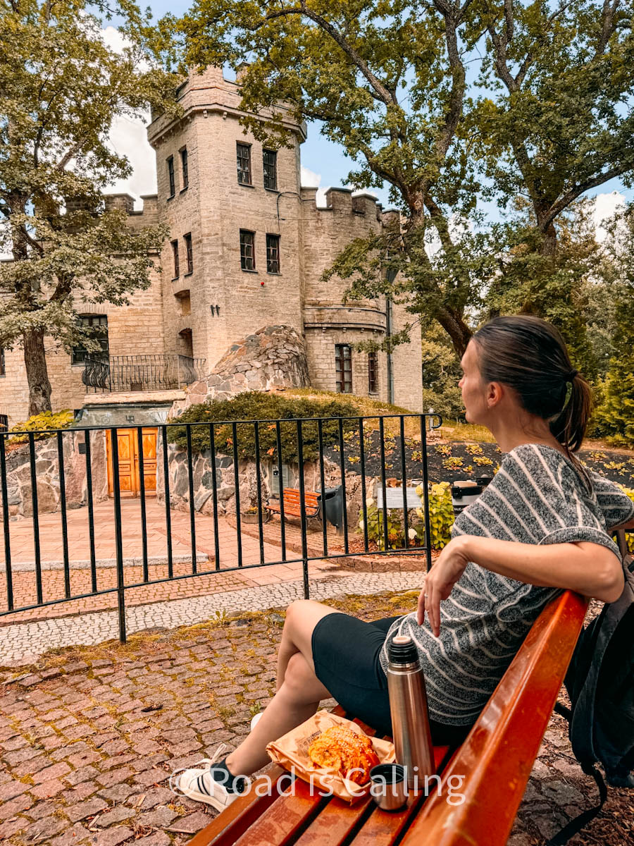 woman is sitting on a bench near Glen castle in Tallinn