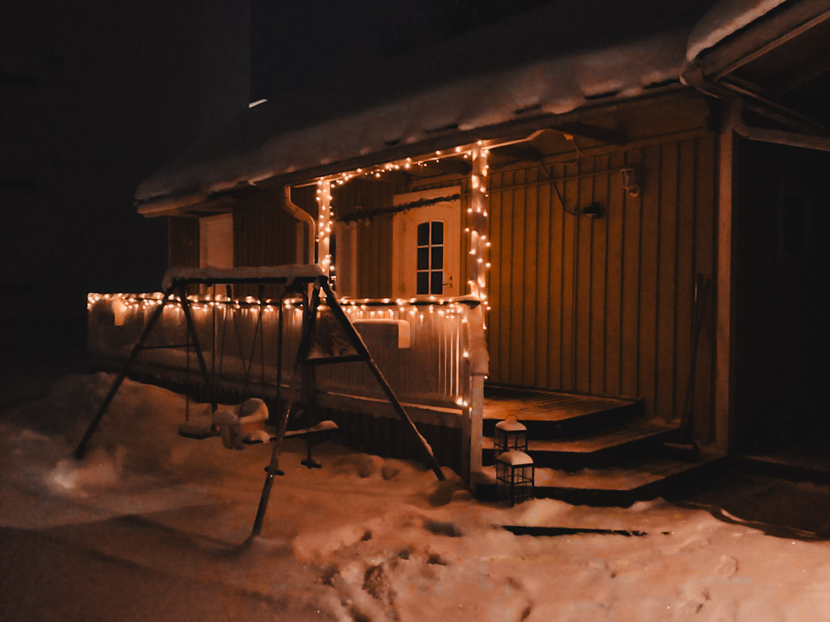 wooden cabin with fairy lights in snowy Rovaniemi