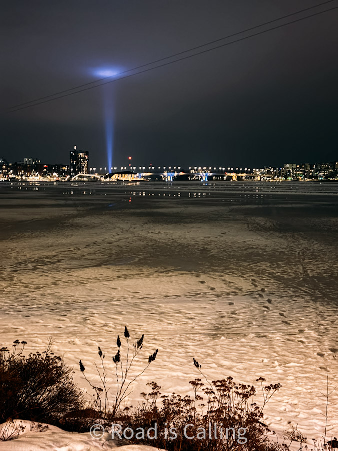 Frozen lake with city lights and blue spotlight beam in Jyväskylä, Finland