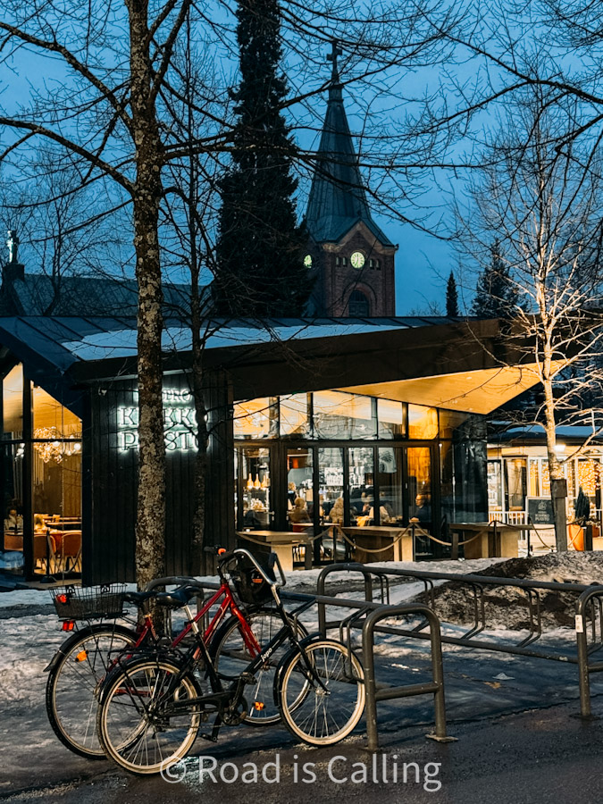 Bicycles parked outside cozy café with church tower in background, Jyväskylä, Finland