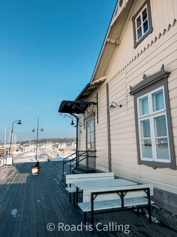 Historic wooden lakeside building with outdoor seating in Jyväskylä Finland