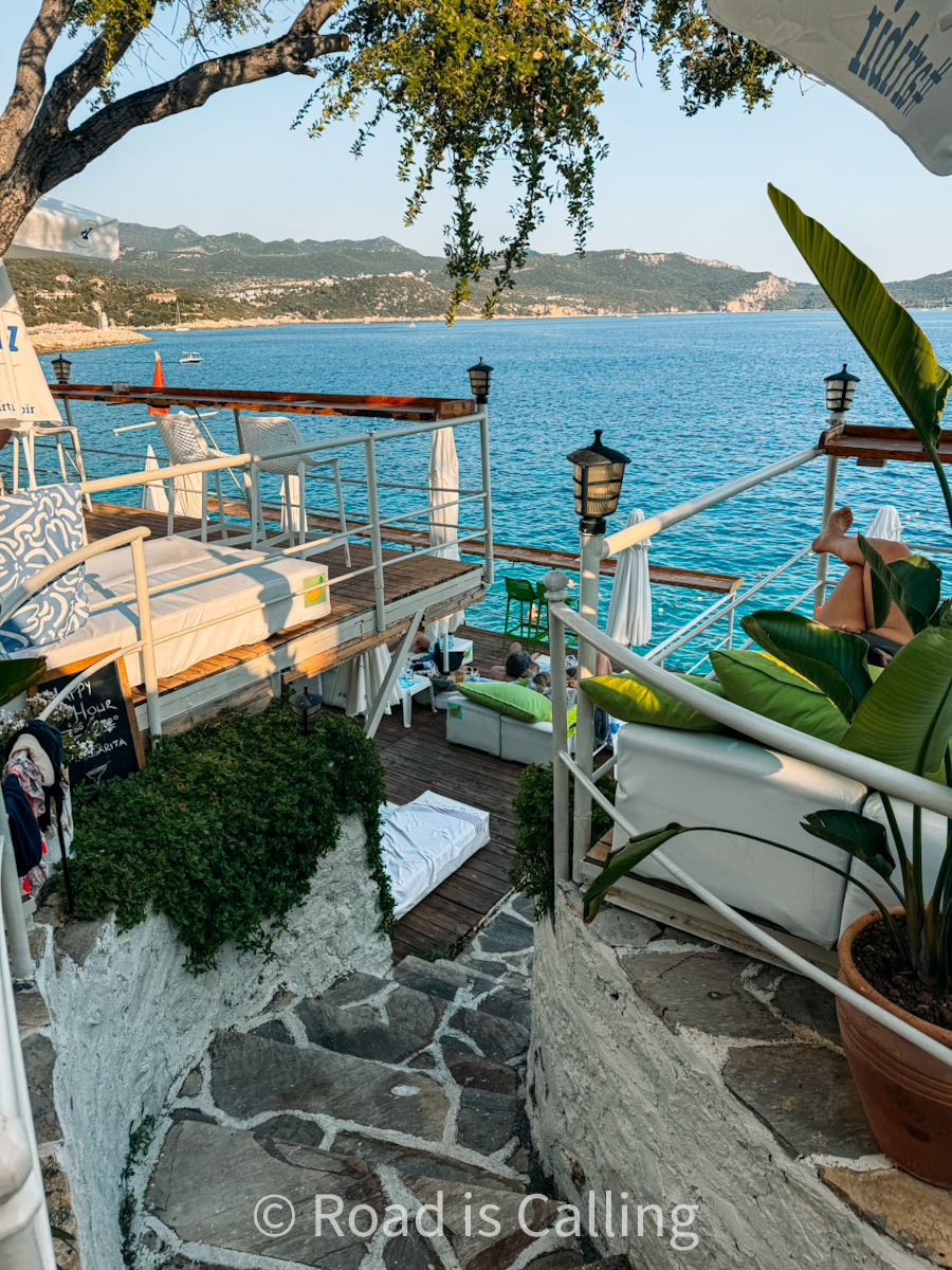 Terraced beach club with loungers and sea view in Kaş, Turkey, surrounded by lush greenery