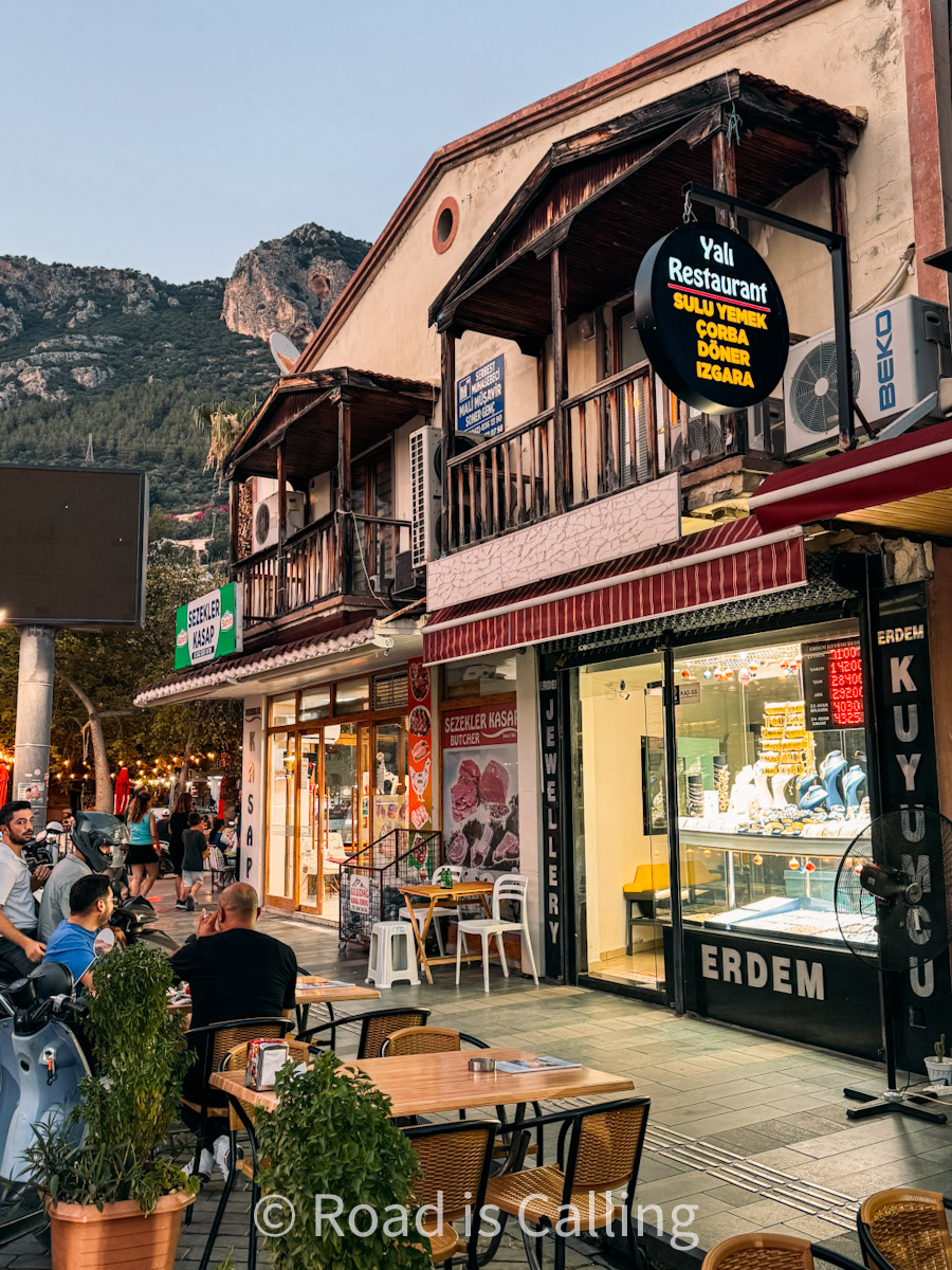 Street in Kas town lined with restaurants, local shops, and outdoor seating in the evening