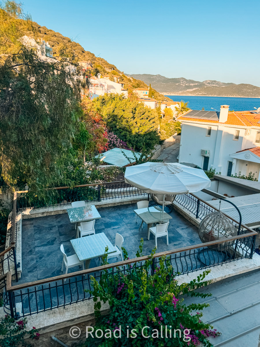Rooftop terrace in Turkey with sea views, white patio furniture, and a hanging egg chair surrounded by greenery