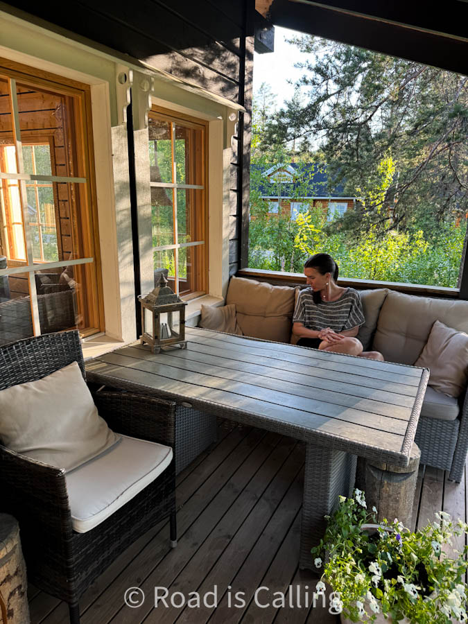 me sitting at the table by the cabin outside in the forest in Lapland