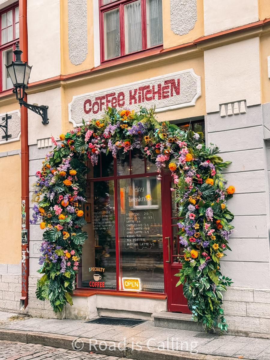 entrance of a cozy breakfast cafe in Tallinn Old Town decorated with flowers