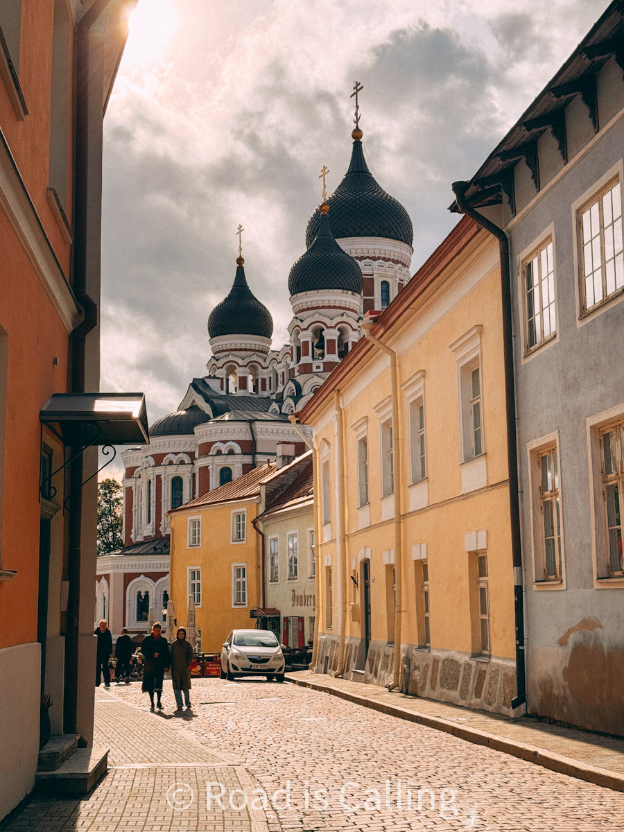 View of Alexander Nevsky Cathedral behind colorful buildings in Tallinn Old Town on a cloudy day