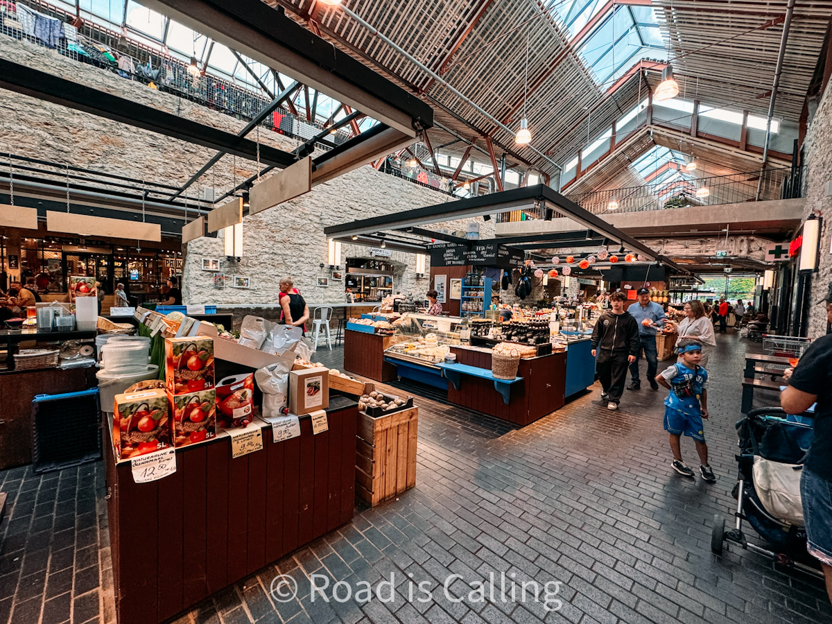 Inside Balti Jaama Turg market in Tallinn with food stalls, local products, and people shopping