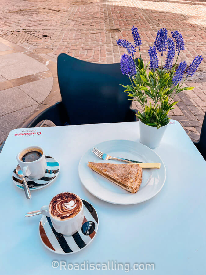 cups of coffee and a cake on a cafe table in Cordoba